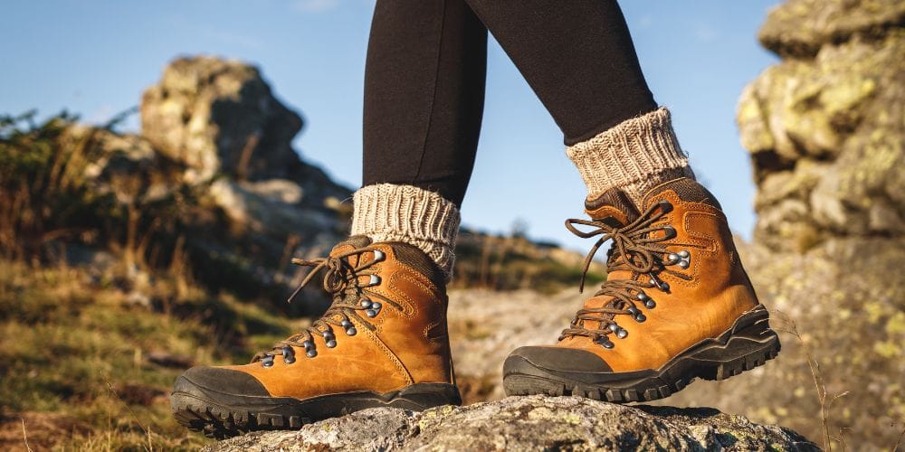 Hiking boots on rocky trail near New York Cabin Rentals surrounded by scenic mountain landscape